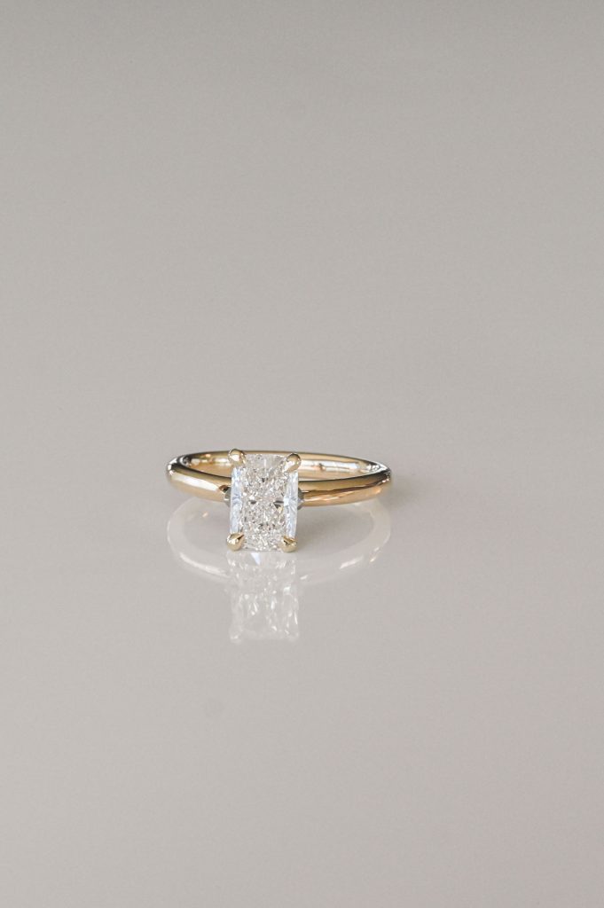 Yellow gold ring with a radiant-cut diamond in a classic four-prong solitaire setting.