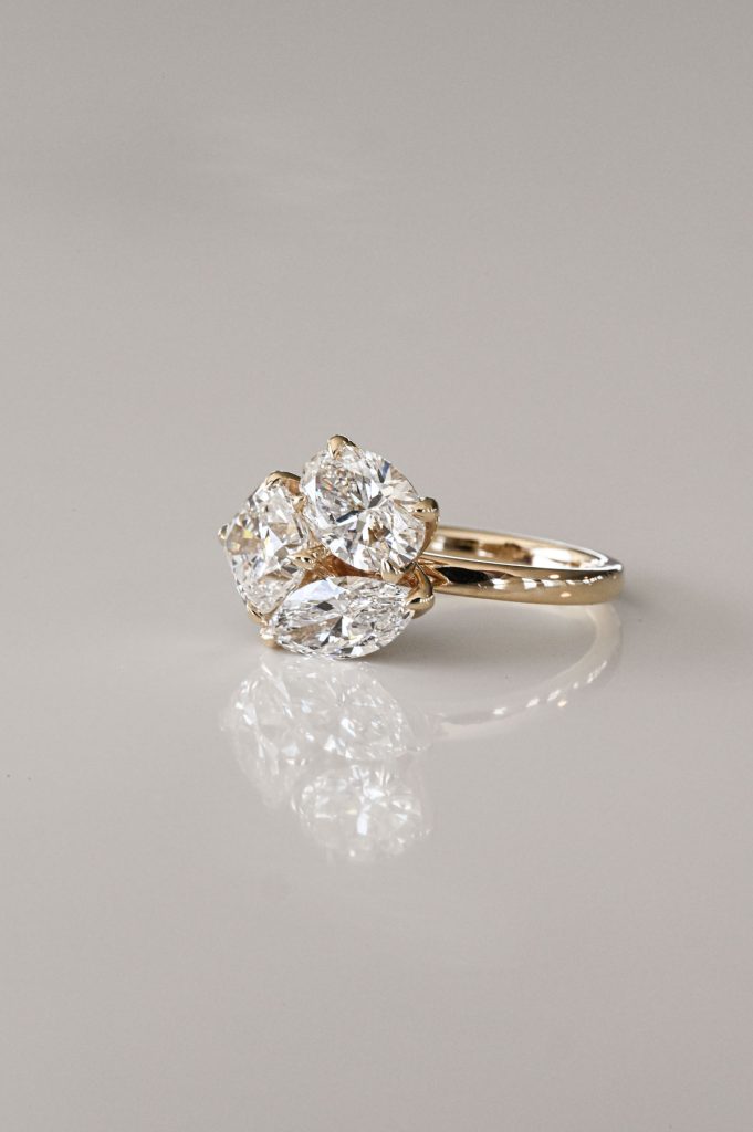 Yellow gold ring featuring three pear-shaped diamonds arranged in a floral bouquet-inspired cluster.