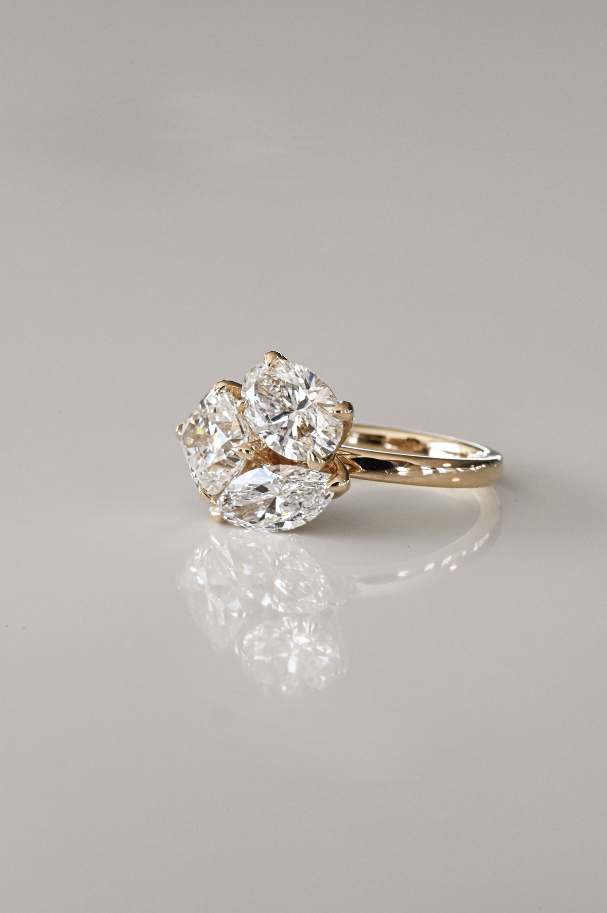 Yellow gold ring featuring three pear-shaped diamonds arranged in a floral bouquet-inspired cluster.